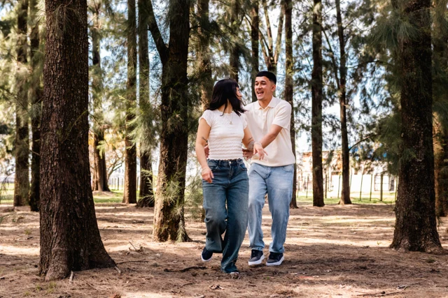 Pareja caminando entre árboles durante su sesión